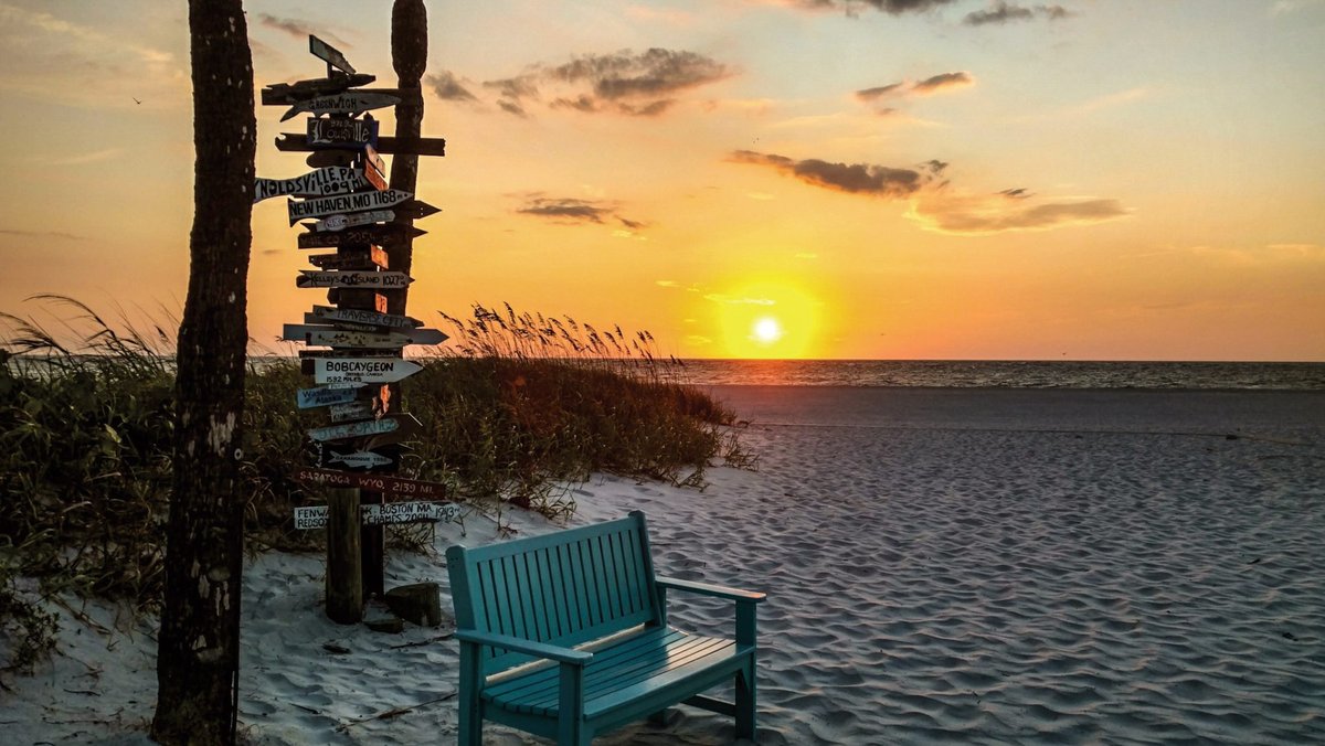 Sunset over Gasparilla Island with a bench and directional signpost